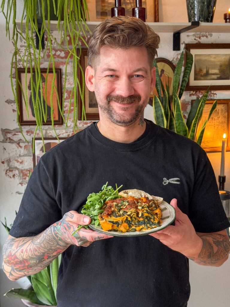 Jan Willem houdt een bord pompoenlasagne met spinazie en rucola vast
