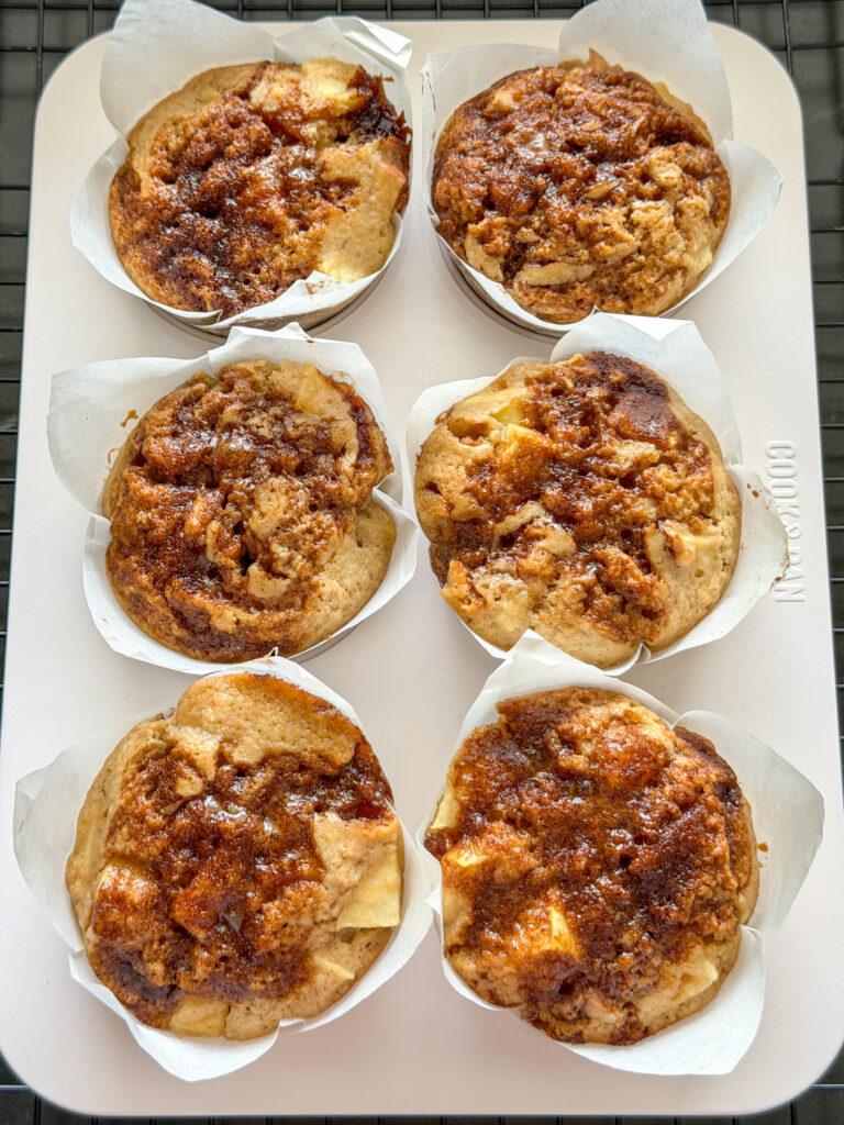 zes goudbruine appel kaneel muffins met kaneelswirl in hoge papieren muffinvormpjes